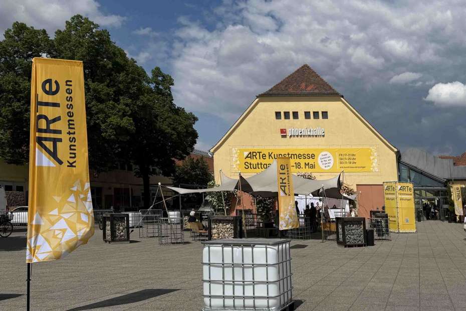 ARTe Stuttgart 2025 - Hinter leeren Regentonnen vorm alten Römerkastell im strahlenden Sonnenschein, unter Wolkengemälden 